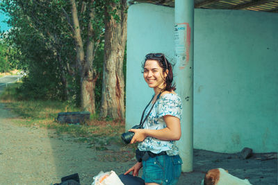 Portrait of smiling young woman sitting outdoors