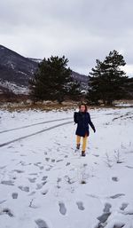 Rear view of woman on snowcapped mountain against sky