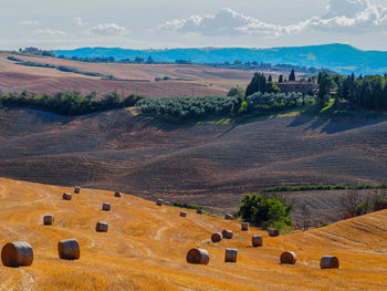 Hay bales on field against sky