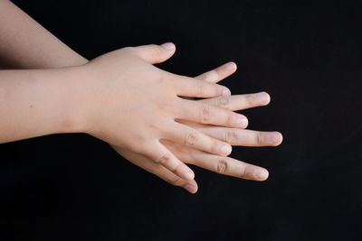 Close-up of woman hand against black background