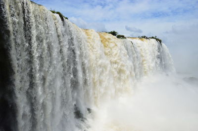 Scenic view of waterfall against sky