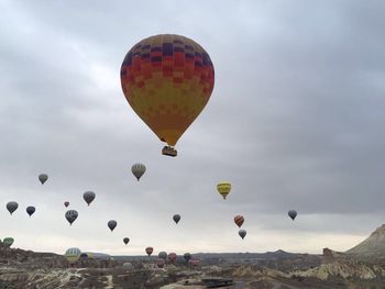 Hot air balloons moving up over landscape against sky