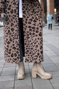 Low section of woman standing on footpath