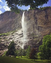 Low angle view of waterfall on cliff