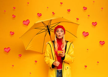 Full length of young woman standing with umbrella