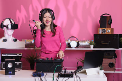 Portrait of young woman using mobile phone while sitting on table