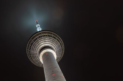 Low angle view of illuminated tower against sky at night