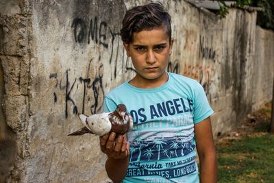 Portrait of teenage boy standing against wall