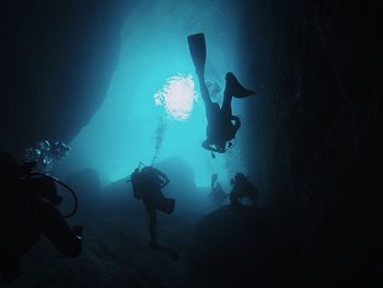 Low angle view of silhouette people scuba diving undersea