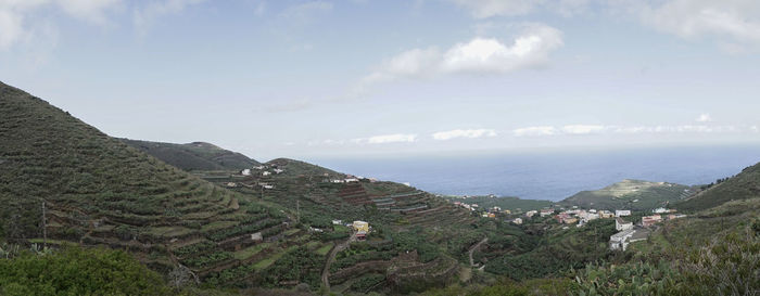 High angle view of field by sea against sky