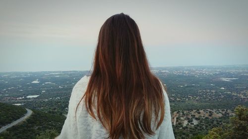 Rear view of woman looking at city against clear sky