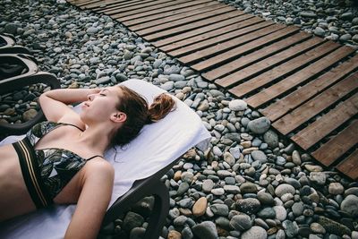 High angle view of woman lying on pebbles