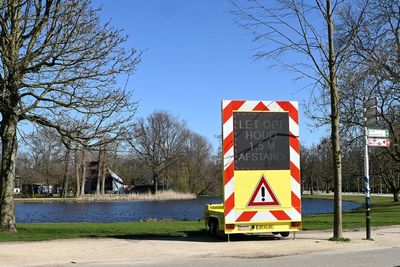 Information sign by road against sky