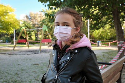 Portrait of girl wearing mask at park