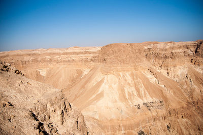 Scenic view of desert against clear blue sky