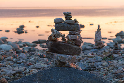 Stack of stones on beach during sunset