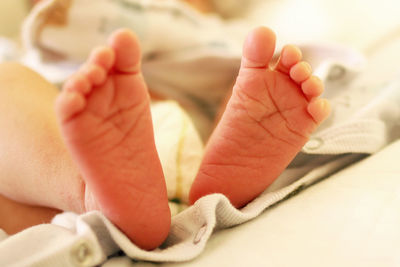 Low section of baby girl lying on bed