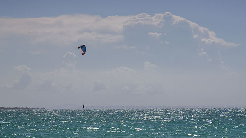 People in sea against sky