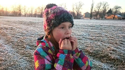 Portrait of girl in snow on field