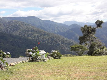 People sitting on mountain against sky