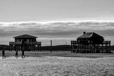 Built structure on beach by building against sky