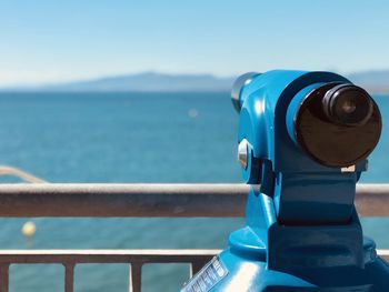 Close-up of coin-operated binoculars against sea