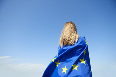 Rear view of woman against blue sky