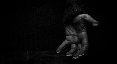 Close-up of human hand against black background