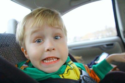 Close-up portrait of happy boy in car