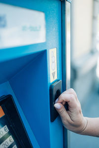 Hand of woman inserting credit card at atm