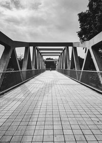 View of footbridge in city against sky