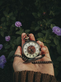 Close-up of hand holding vintage clock