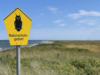 Information sign on land against sky