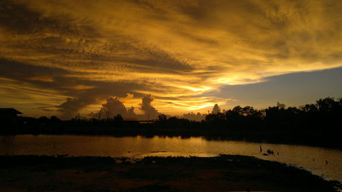 Scenic view of lake against orange sky