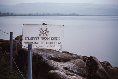 Information sign on rock by lake