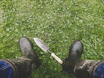 Low section of man standing by work tool on field