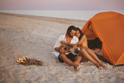 Young couple sitting on beach