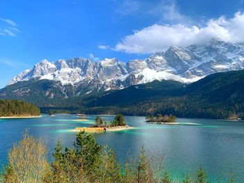 Scenic view of lake and mountains against blue sky