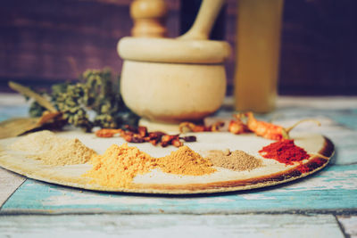 Spices by mortar and pestle on table