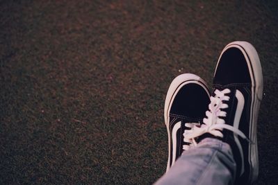 Low section of person wearing shoes on field