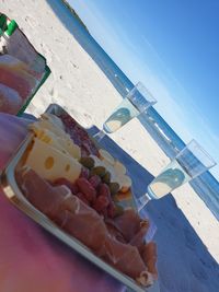 Close-up of food on table at beach against sky