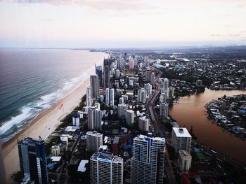 High angle view of city by sea against sky