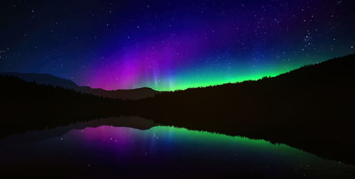 Scenic view of aurora the northern lights, or aurora borealis,  mountains against sky at night