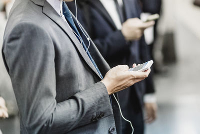 Midsection of businessman using mobile phone