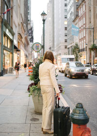 Rear view of woman walking on city street