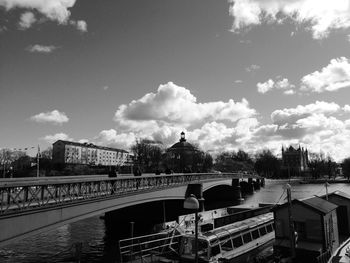 Bridge over river against cloudy sky