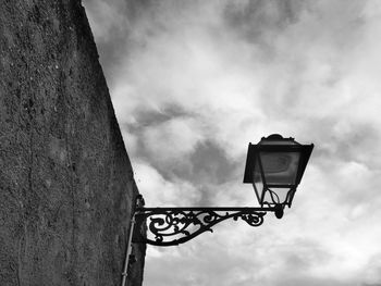 Low angle view of street light against cloudy sky