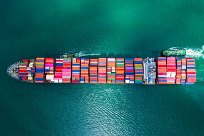 High angle view of container ship import export international sailing in green sea 