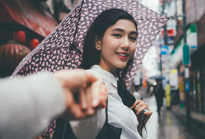 Portrait of smiling young woman in city