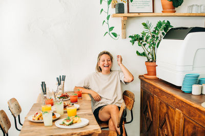 Young woman laughing while sitting in cafe